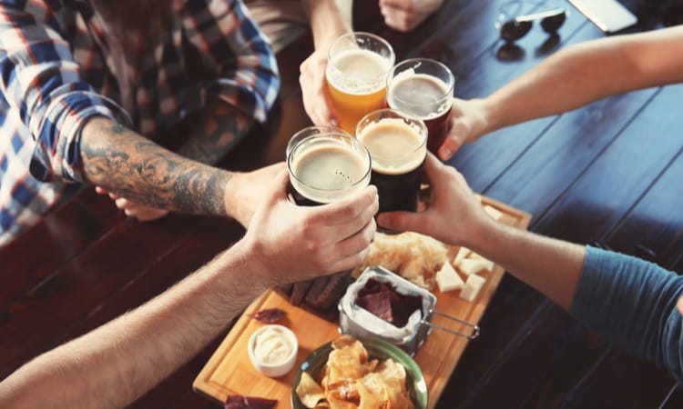 group toasting beer with bar food